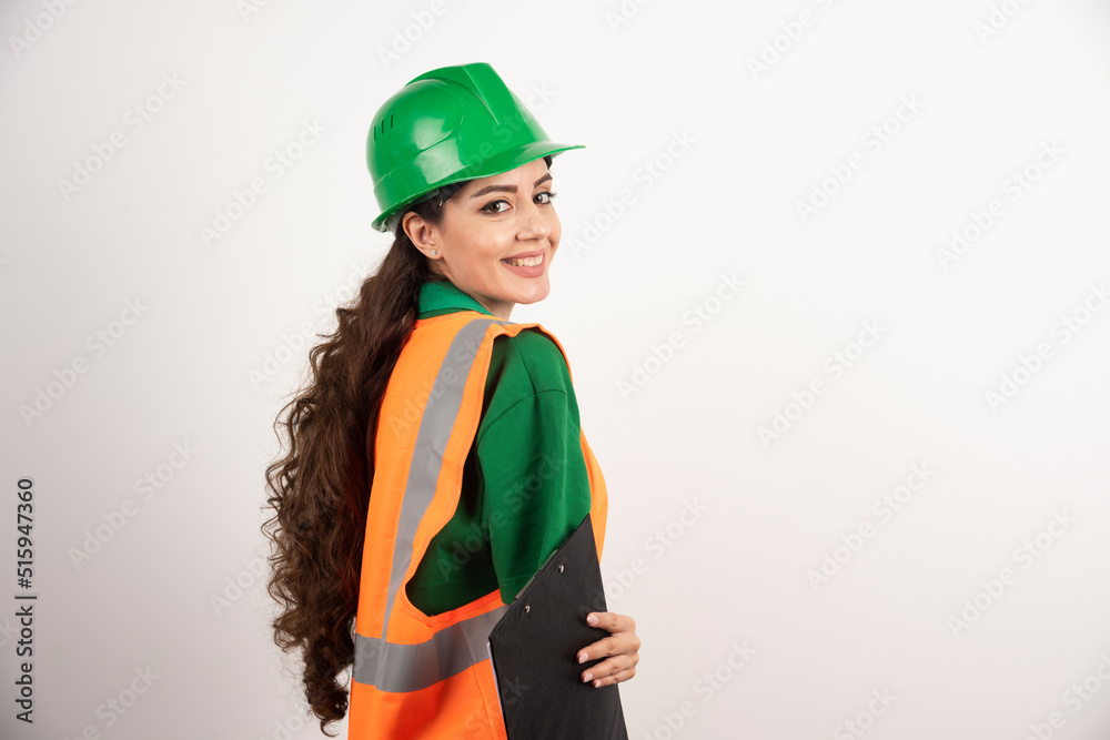 Smiling female constructor with clipboard Smiling female constructor with clipboard