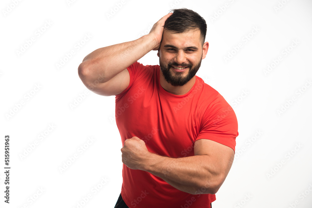 Sportive man in red shirt demonstrating his muscles Sportive man in red shirt demonstrating his muscles