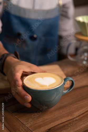 a barista holding a cup of coffee