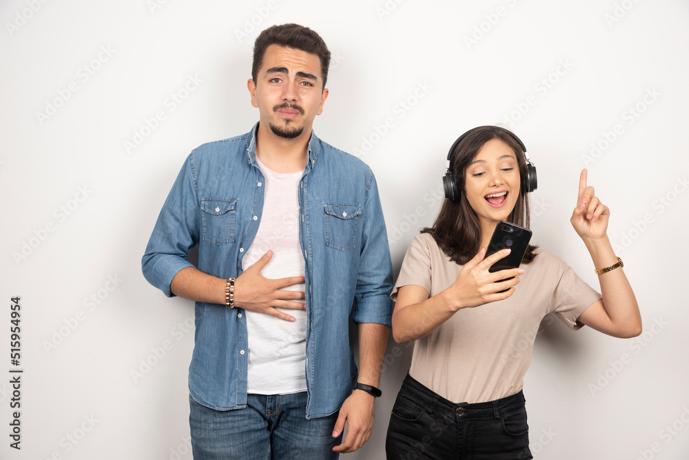 Man having breakdown while woman dancing around music Man having breakdown while woman dancing around music