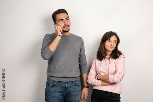 Woman standing while man talking with telephone