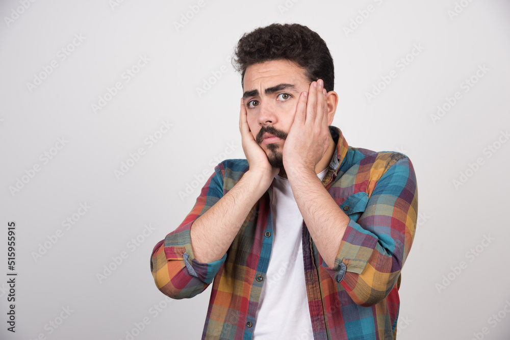 Shocekd young guy holing his hands to his head Shocekd young guy holing his hands to his head