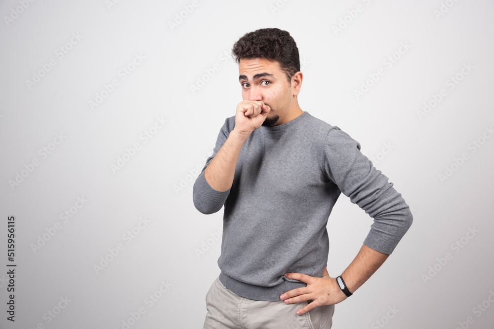 Young man with mustache putting fist to mouth Young man with mustache putting fist to mouth