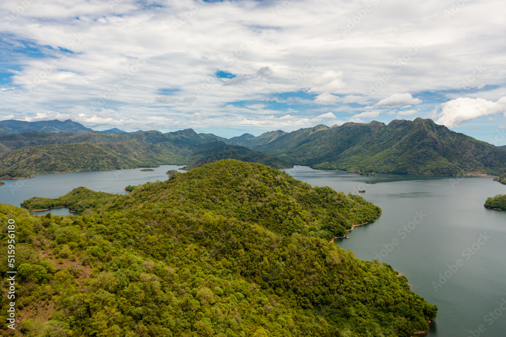 Top view of mountain lake among hills with tropical vegetation and blue sky with clouds. Randenigala reservoir, Sri Lanka.