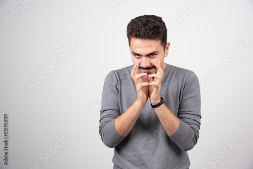 Sly man in gray t-shirt against white background © azerbaijan-stockers