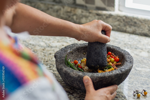Unrecognizable woman preparing a traditional mexican sauce in a molcajete photo