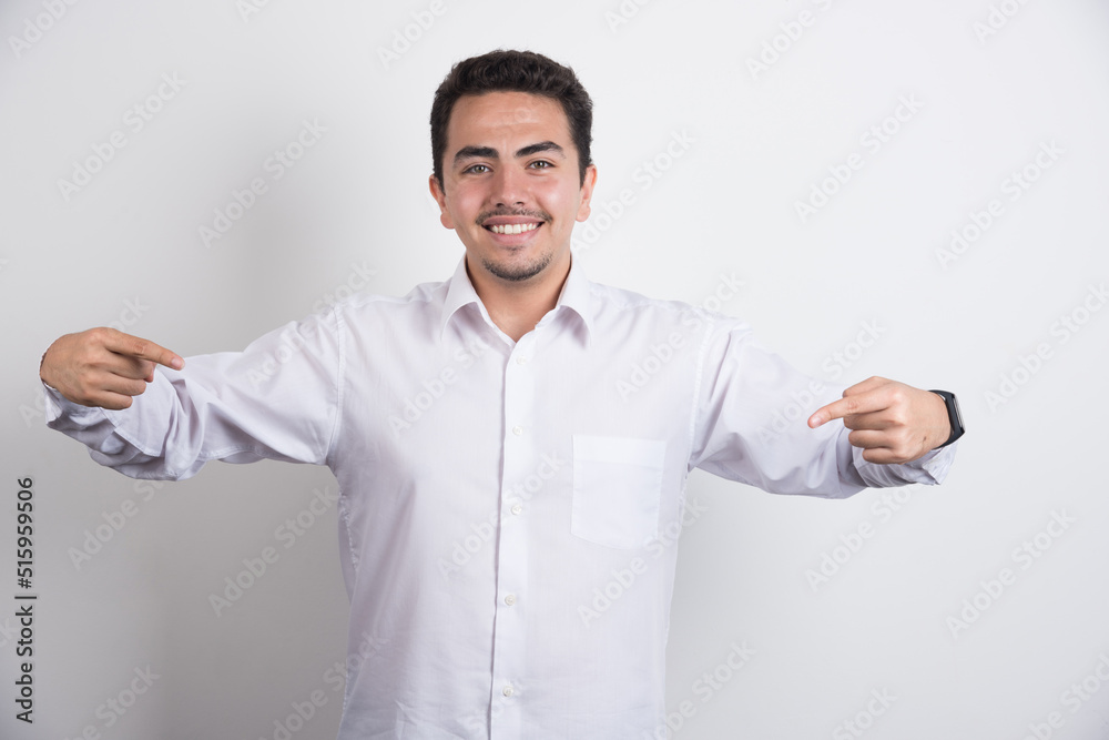 Young businessman pointing middle area on white background Young businessman pointing middle area on white background