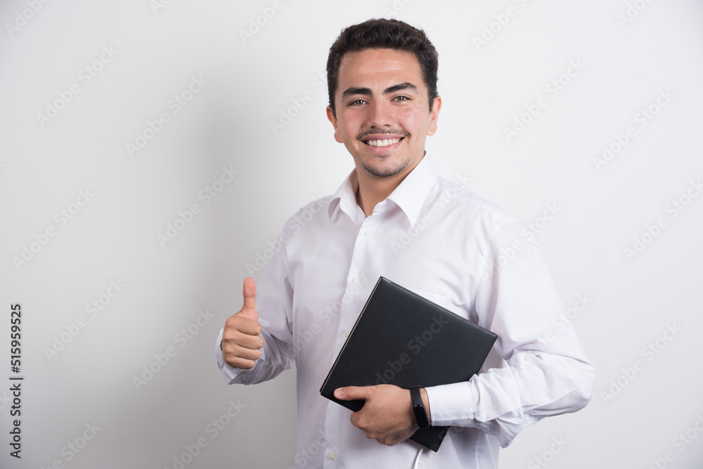 Businessman holding laptop and showing thumbs up on white background Businessman holding laptop and showing thumbs up on white background