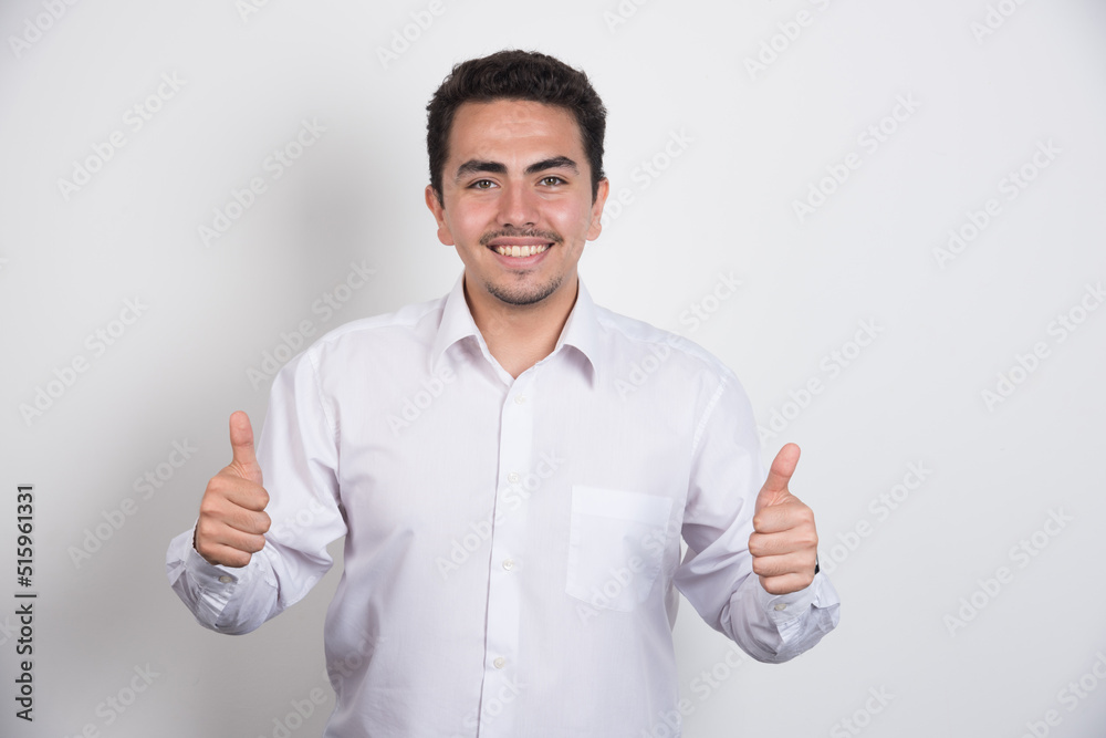 Young businessman showing thumbs up on white background Young businessman showing thumbs up on white background
