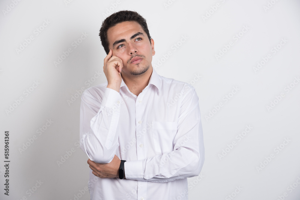 Young businessman thinking hard on white background Young businessman thinking hard on white background