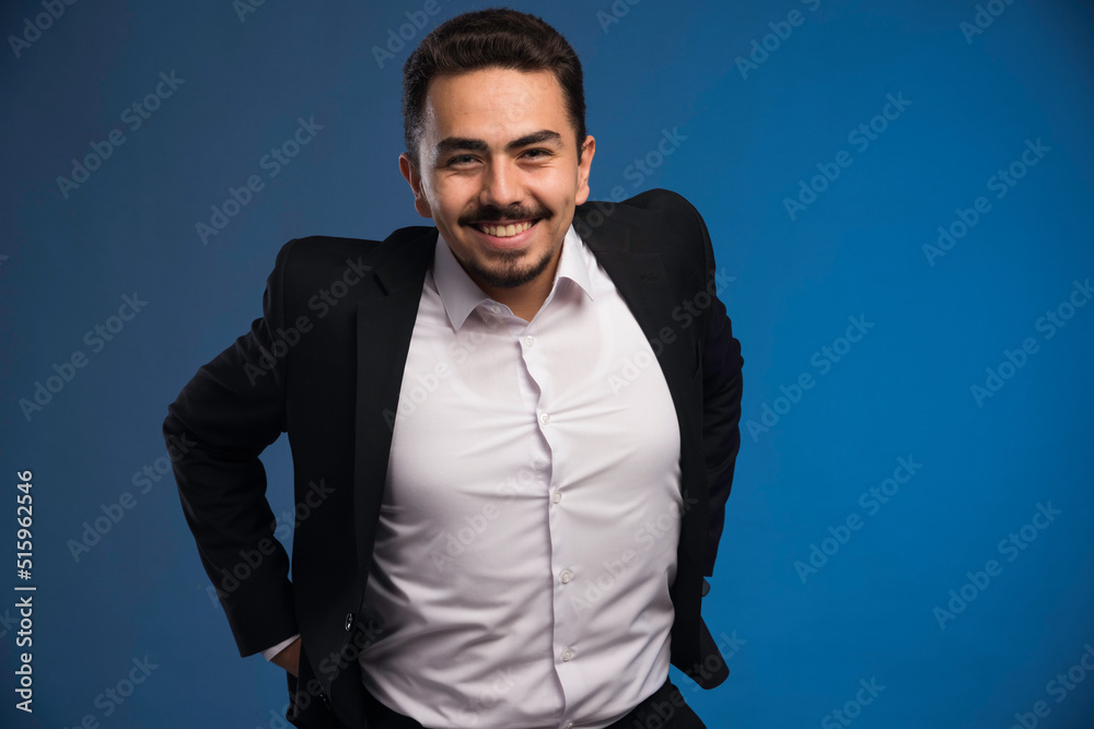 Obraz premium Businessman in black suit smiling positively