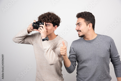 Two young men taking pictures with camera