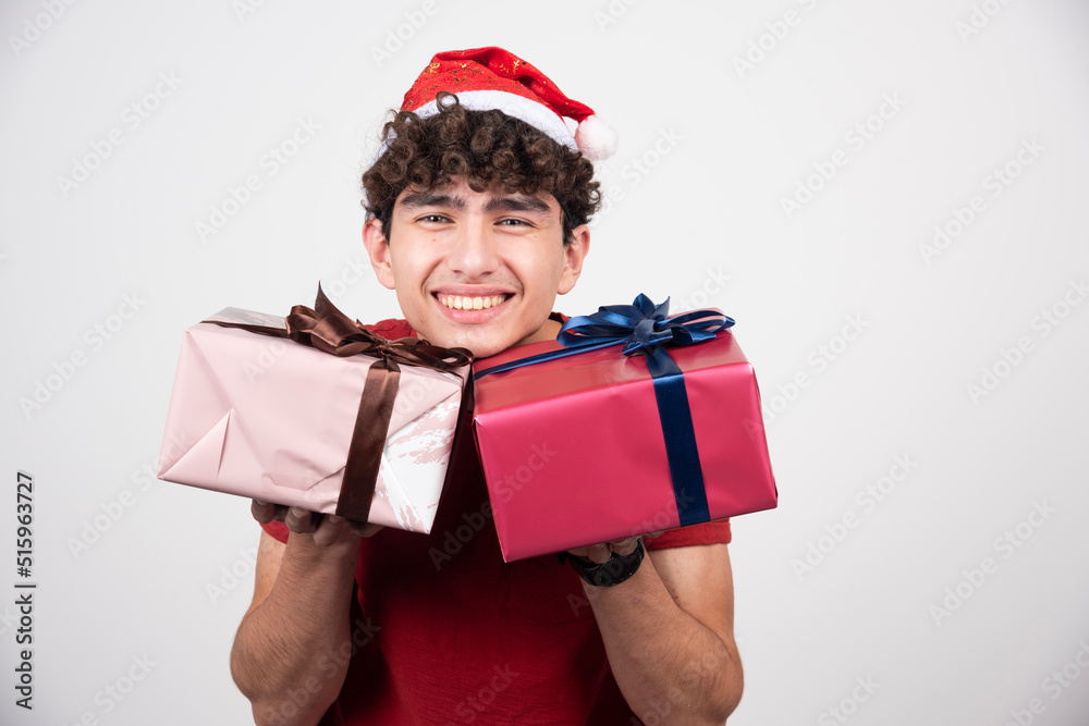 Young man holding gift boxes and smiling Young man holding gift boxes and smiling