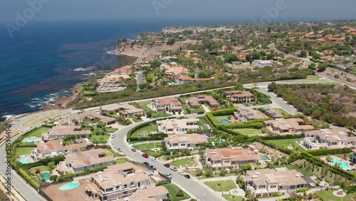 Aerial shot of homes in Palos Verdes next to Pacific Ocean cliffs and waves