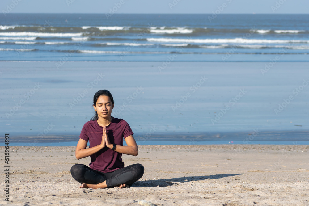 Woman sitting in a namaskar pose. Yoga at a beach, morning, Jogging, workout, exercise, healthy life, diet, lifestyle, sedentary, active, fit, fresh, fitness, periods, sunlight, muscle, life balance Woman sitting in a namaskar pose. Yoga at a beach, morning, Jogging, workout, exercise, healthy life, diet, lifestyle, sedentary, active, fit, fresh, fitness, periods, sunlight, muscle, life balance