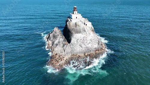 The cold, calm water of the Pacific Ocean surrounds the deactivated Tillamook Rock Lighthouse off the scenic Oregon coast. The isolated, historic lighthouse was originally built in 1880.