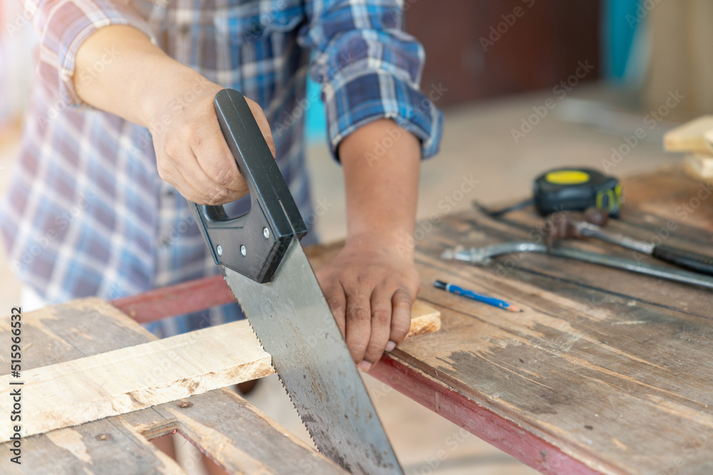 Handyman cutting wood with hand saw Handyman cutting wood with hand saw