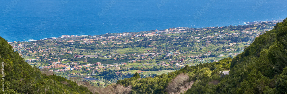 View of the coastal city, Puerto de Tazacorte, from the mountain with the sea in the background from above. Houses or holiday accommodation by the ocean in the tourist destination of La Palma, Spain