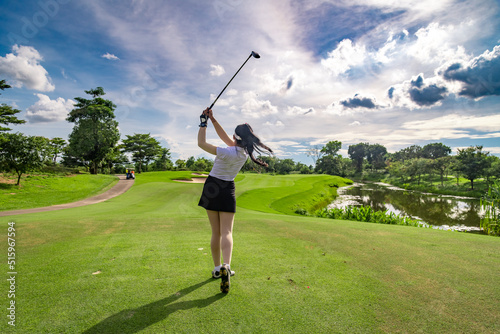 Professional woman golfer teeing golf in golf tournament competition at golf course for winner