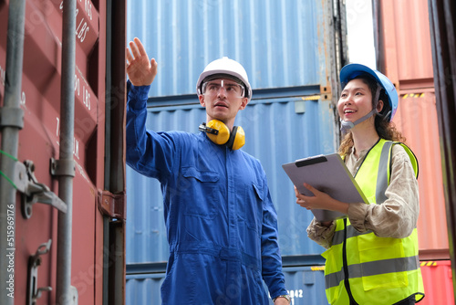 Caucasian foreman and female engineer inspect the cargo containers.