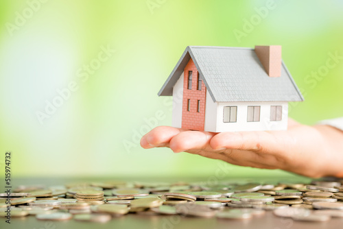 house with coins on bokeh background
