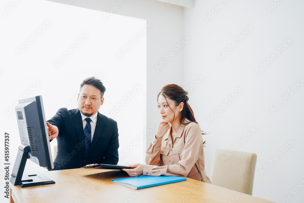オフィスで仕事をする2人のビジネスパーソン オフィスで仕事をする2人のビジネスパーソン
