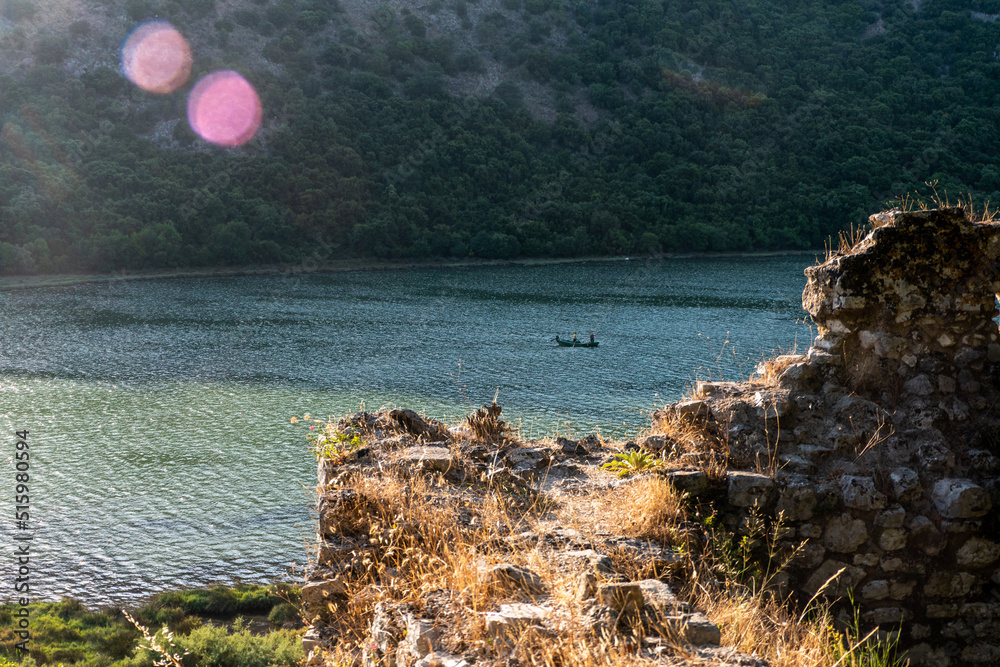Φωτογραφία Ksamil, Albania, A small fishing boat in lake Butrint surrounded by ruins in the  National Park of Butrint, an ancient city from Greek and Roman times