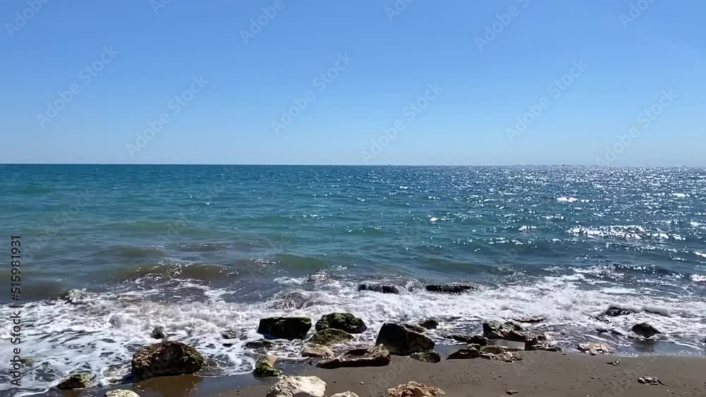 Slow motion of waves crashing on the beach. Sea waves splashing on the coastline. Summer vacation and beauty of nature concept Slow motion of waves crashing on the beach. Sea waves splashing on the coastline. Summer vacation and beauty of nature concept