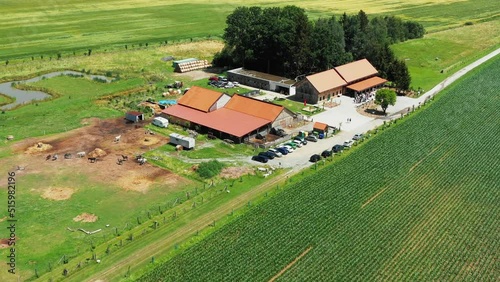 Backward flight from a farm with outdoor restaurant over a neighboring intensively cultivated corn field in the Czech Republic