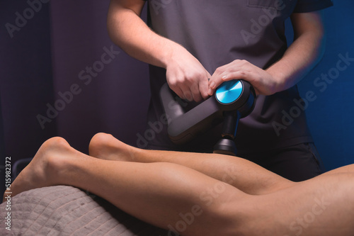 Rehabilitation. Massage therapist performs prophylactic percussive massage