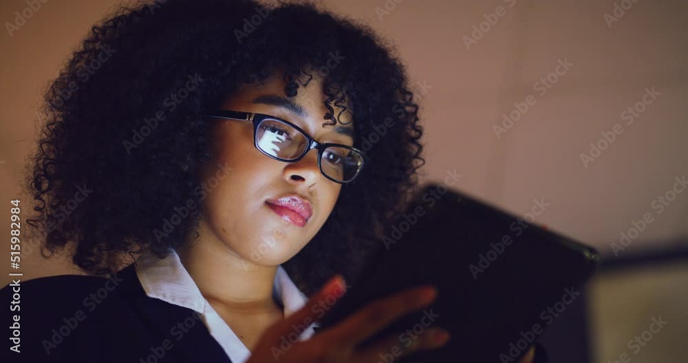 Young business woman scrolling online on a digital tablet while working late in an office. Corporate female professional searching the internet while doing overtime. Lady browsing the web for ideas