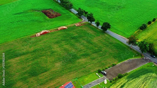 Aerial view of a meadow area on the edge of a country road with a lookout tower
