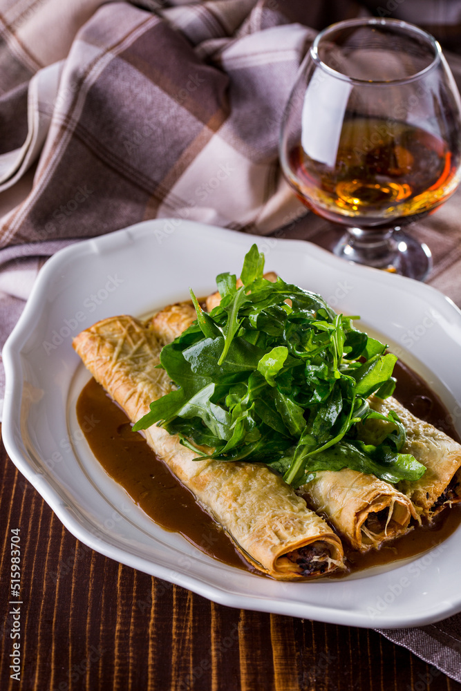 Pancakes with veal and cheese and a glass of cognac Pancakes with veal and cheese and a glass of cognac