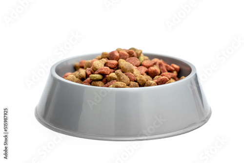 Plastic animal bowl with dry feed. Isolated on white.