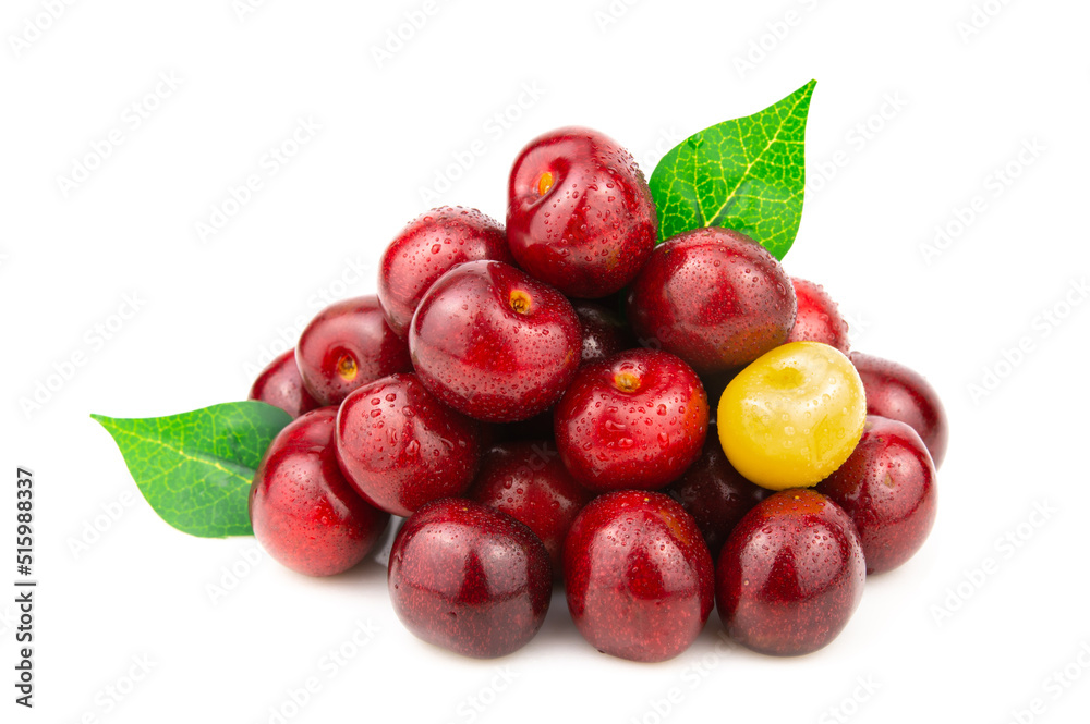 A handful of red cherries with one yellow berry. Green leaves stick out between the berries A handful of red cherries with one yellow berry. Green leaves stick out between the berries