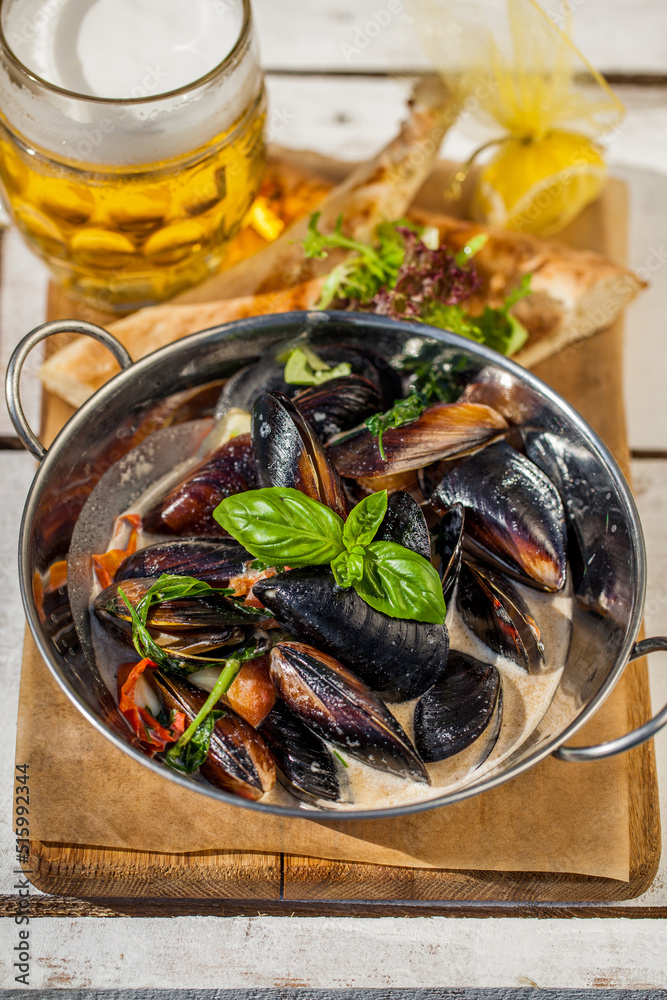 Fried mussels in a creamy sauce with a glass of beer Fried mussels in a creamy sauce with a glass of beer