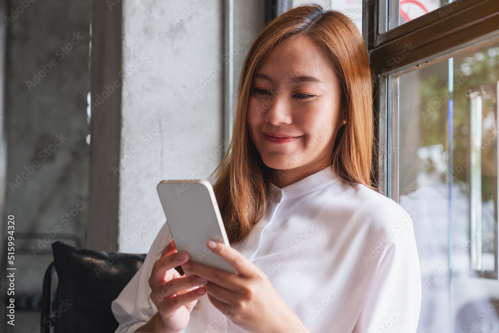 Portrait image of a beautiful young woman holding and using mobile phone Portrait image of a beautiful young woman holding and using mobile phone