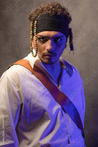 Annoyed young pirate stand on blue light and looking at camera