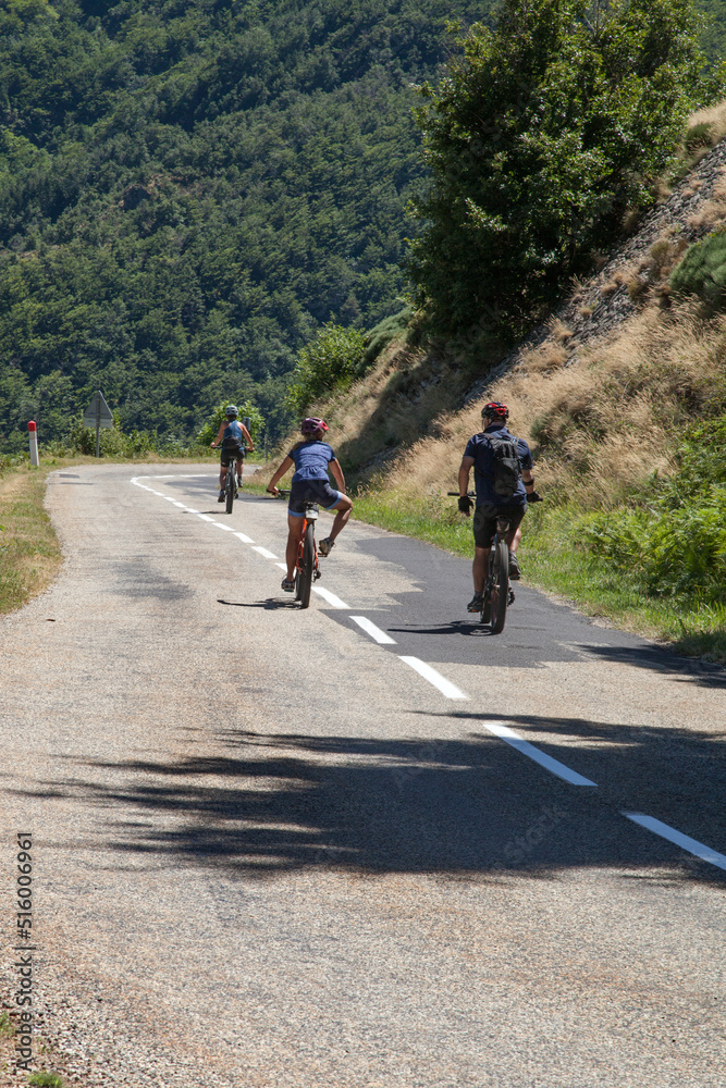 Trois cyclistes à VTT descendant un col