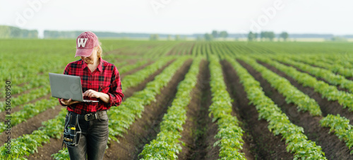 Confident mature farmer in agricultural field. Potato field.
