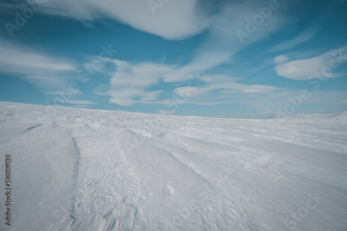 Conceptual background of snow and blue sky with beutiful clouds. Copy space. Photo taken in Helags Mountain area, swedish Lapland.