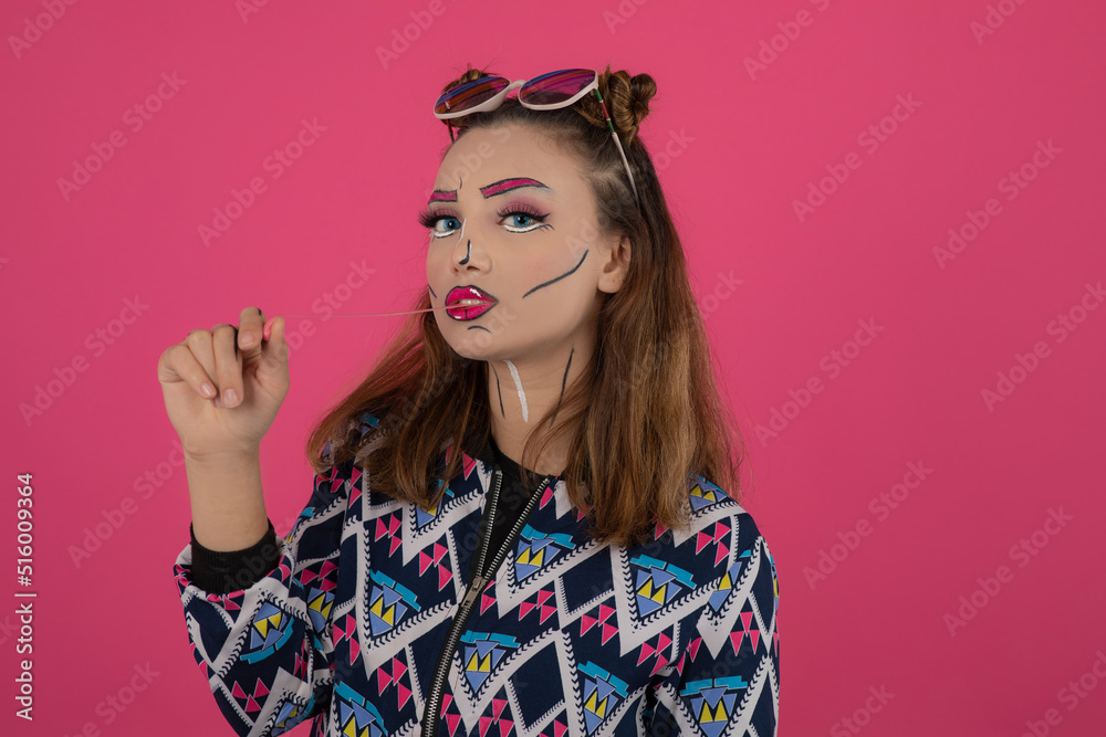Fototapeta premium Close up portrait of young girl wearing creative makeup and looking at camera