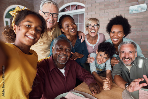 Happy multiracial extended family having fun while taking selfie on patio.