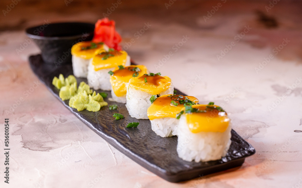 japanese dish rice rolls with cheese on a black plate japanese dish rice rolls with cheese on a black plate