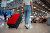 Traveler with suitcase in airport concept.Young girl walking with carrying luggage and passenger for tour travel booking ticket flight at international vacation time in holiday rest and relaxation..