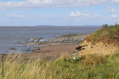People search for fossils on the rock pavements on Kilve beach near East Quantoxhead in Somerset, England. Strata of rock date back to the Jurassic era and create a strange alien landscape