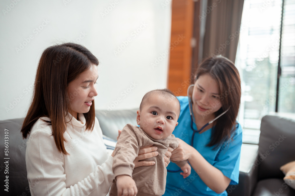 Asian Female doctor pediatrician holding stethoscope checkup child newborn baby boy patient visit doctor with mother at home, mom protection children medical care concept. Asian Female doctor pediatrician holding stethoscope checkup child newborn baby boy patient visit doctor with mother at home, mom protection children medical care concept.