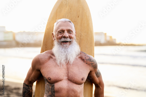 Photography Senior fit man having fun surfing on tropical beach - Elderly healthy people lif