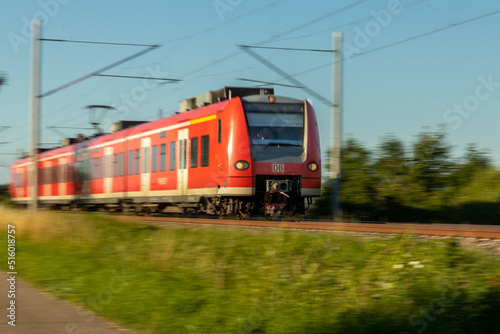 Ein Personenzug auf Gleis mit elektrischer Oberleitung