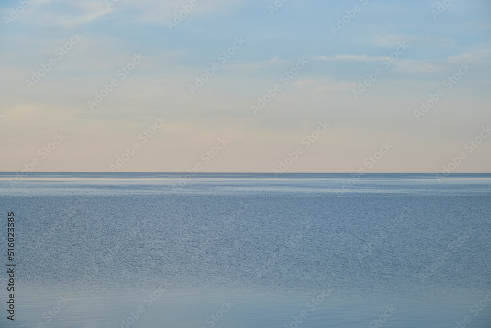 Blue pond and horizon line in distance. Clear summer sky. Beautiful seascape. Lake Ilmen, Novgorod region, Russia.